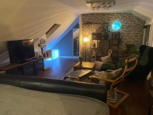 a living room with a couch and a tv at The Rusty Corner in Solingen