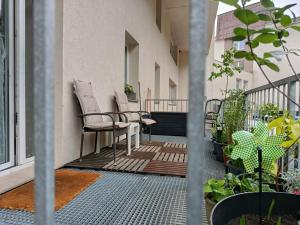 a balcony with chairs and plants on a building at Apartmán s terasou REZIDENCE 300 Všemina in Všemina +5 photos