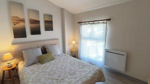 a bedroom with a bed and a large window at Appartement du Port Neuf in Lanton