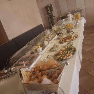 a long table with many plates of food on it at Hotel Kaiserpfalz in Fritzlar