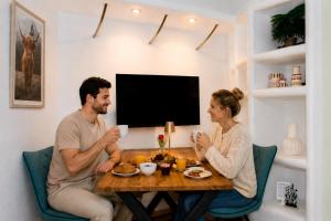 a man and woman sitting at a table drinking coffee at Rost Apartments - Design Ferienhaus mit Kamin und Hängematte in Laufen