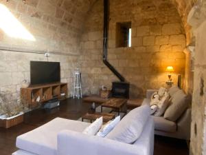 a living room with a white couch and a tv at Ermita de la Tuda-Villaescusa de las Torres in Villaescusa de las Torres