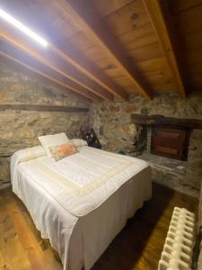 a bedroom with a large bed in a stone wall at Ermita de la Tuda-Villaescusa de las Torres in Villaescusa de las Torres