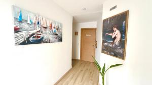 a hallway with two large paintings on the wall at Hostal playa Dreams náutico Adults in Garrucha +32 photos