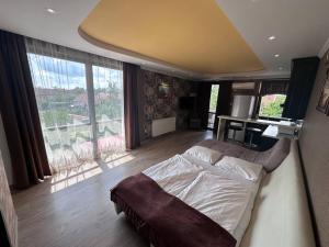 a bedroom with a bed and a large window at Art Apartments in Hajdúszoboszló