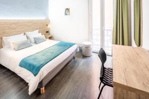 a bedroom with a bed and a large window at Hôtel Estival Arriel entièrement climatisé in Lourdes