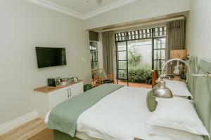 a bedroom with a bed and a tv and a window at Highlands House in Harare +92 photos