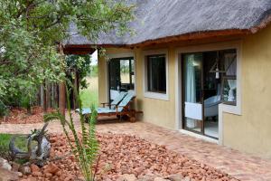 a house with a bench on the side of it at Bushveld Venue in Mabula