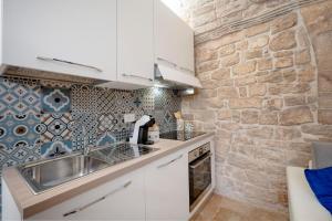 a kitchen with a sink and a stone wall at Il Corallo in Molfetta +4 photos
