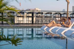a couple of people sitting on rafts in a swimming pool at Heritage Ham Long Hotel and Spa in Hanoi