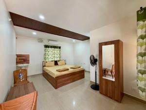 a bedroom with a bed and a mirror in it at AR Cottage in Udupi