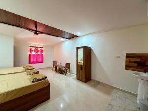 a bedroom with two beds and a table and a window at AR Cottage in Udupi +9 photos