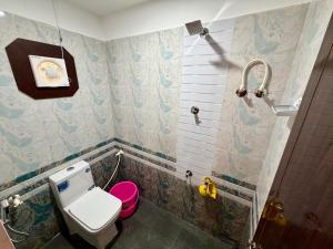 a small bathroom with a toilet and a shower at AR Cottage in Udupi