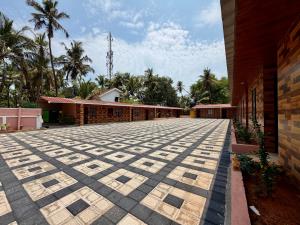 an empty courtyard of a building with palm trees at AR Cottage in Udupi