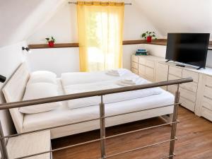 a living room with a white couch and a tv at M3-Apartmány in Martin