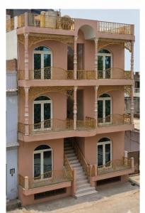 a pink building with balconies and stairs at Ray of Maya near to taj mahal in Agra