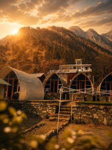 a group of domes with mountains in the background at Vintage Vista Camps in Kasol