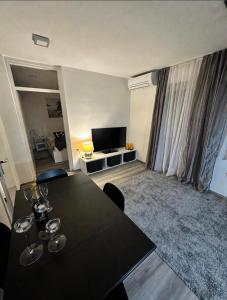 a living room with a black table and a television at Hiška Orel Terme Čatež in Čatež ob Savi