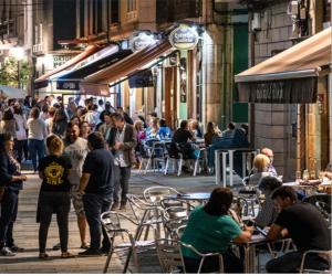 a group of people sitting at tables on a street at Bruma in Vilagarcia de Arousa