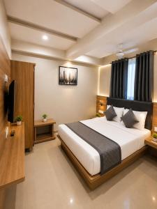 a bedroom with a large bed and a television at Hotel Royal Blue in Modāsa