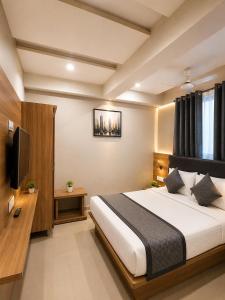 a bedroom with a large bed and a television at Hotel Royal Blue in Modāsa