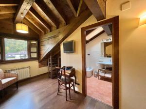 a living room with a table and a mirror at Hotel Rural El Fundil in El Pino