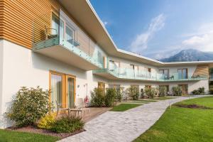 a building with a balcony and a lawn at Hotel Atilius - Adults Only in Limone sul Garda