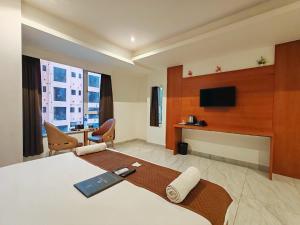 a hotel room with a bed and a flat screen tv at Hotel Sterling Executive in Navi Mumbai