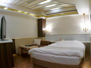 ein Hotelzimmer mit einem Bett und einer Couch in der Unterkunft D'or ドール - レジャーホテル in Mochimune