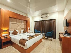 a hotel room with a bed and a desk and a television at Hotel Sterling Executive in Navi Mumbai +49 photos