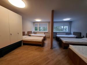 a room with three beds and two windows at Nemunėlio vitražai in Nemunėlio Radviliškis