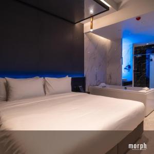 a white bed in a room with a blue light at morph Bangkok Hotel in Bangkok +10 photos