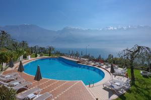 a swimming pool with chairs and a view of the ocean at Hotel Atilius - Adults Only in Limone sul Garda