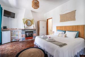 a bedroom with two beds and a fireplace at Vivenda Aromas do Algarve in Monte Raposo