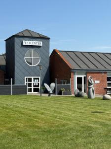 a building with sculptures in front of a grass field at Struer udlejning - lejlighed 1 Bredgade 62 C in Struer