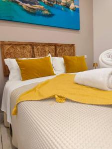 a bed with a yellow blanket on top of it at "Il Vecchio Salone" appartamento in pieno centro con garage privato in Lecce
