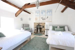 two beds in a room with a fireplace at The Boathouse on the Atlantic Sea in Liscannor
