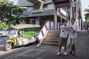 two men standing on a sidewalk looking at a map at Courtyard by Marriott Bangkok in Bangkok