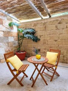 a table with two chairs and a table with fruit on it at "Il Vecchio Salone" appartamento in pieno centro con garage privato in Lecce