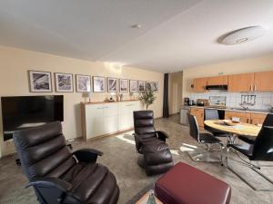 a living room with a table and chairs and a kitchen at Ferienwohnung Kleine Müritz in Rechlin +7 photos