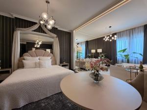 ein Schlafzimmer mit einem großen Bett und einem Tisch in der Unterkunft Hotel Luxor in Lublin + 74 Fotos