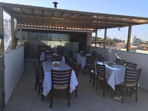 un restaurante con mesas y sillas en la azotea en Pousada Vila Forte, en Cabo Frío