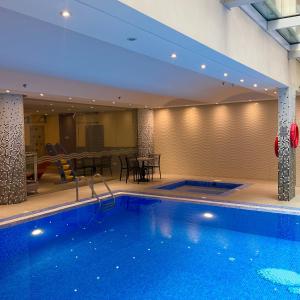 a large swimming pool in a hotel with a table at Mandarin Alshamal Hotel Apartments in Riyadh