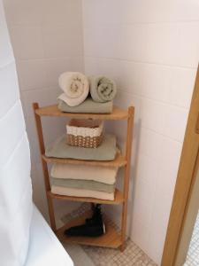 a stack of towels on a wooden shelf in a bathroom at Thomas Haus 1 in Günzburg +8 photos
