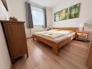 a bedroom with a bed and a dresser in it at Ferienwohnung Kleine Müritz in Rechlin