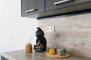 a counter with a coffee maker and two cups on it at Cozy Cottage with Spa - Welkeys in Moliets-et-Maa +6 photos