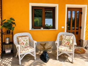 two wicker chairs and a table on a patio at Nortra apartment in Tolmin