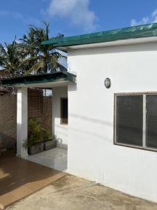 a white building with a window and palm trees at Villa Mondoukou Beach in Île Bouët