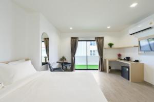 a bedroom with a large white bed and a desk at Global Hotel Pratunam Bangkok in Bangkok +71 photos