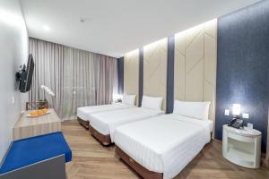 a hotel room with two beds and a tv at Aston Kemayoran City Hotel in Jakarta